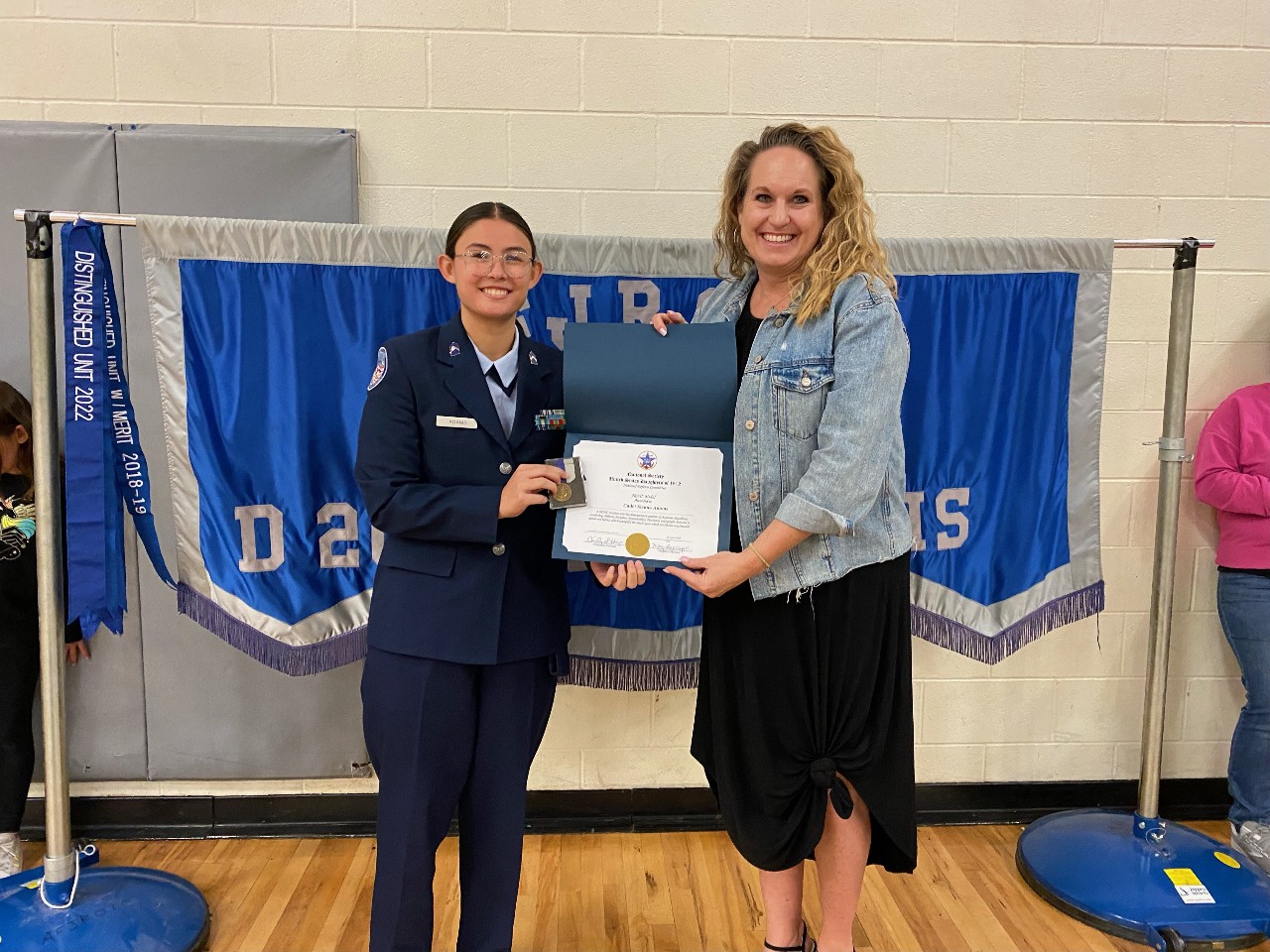 Cadet and principal holding her award certificate